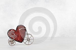 Toy bike carrying big red heart. Valentines day minimalism background