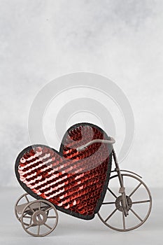 Toy bike carrying big red heart. Valentines day minimalism background