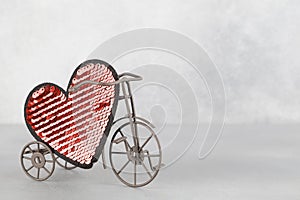 Toy bike carrying big red heart. Valentines day minimalism background