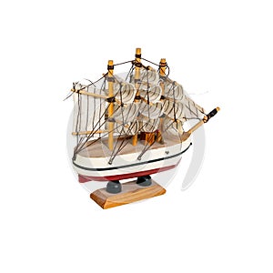 Toy boat sailboat on a wooden stand isolated on a white background