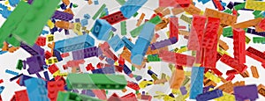 Toy bricks of all colors of the rainbow in flight on a white background. Square. 3D illustration. 3D rendering