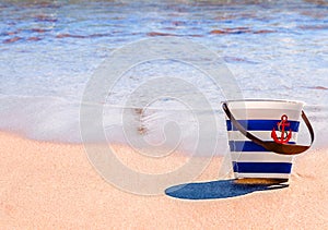 Toy bucket on a beach background