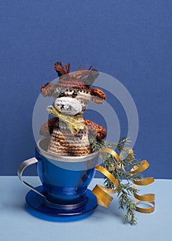 Toy bull symbol of 2021 in blue Cup on blue background