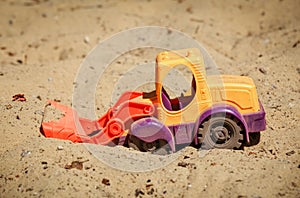 Toy Bulldozer in the sand. A small digger