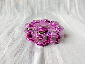 A toy called spinner is purple in color with a unique shape