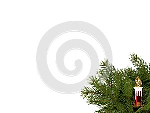 Toy candle on a background of fir branches isolated on a white b
