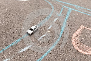 Toy car on a asphalt. chalk painted road markings. right-hand movement, rotation and strip