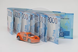 Toy car on the background of banknotes, purchase, insurance and the cost of car ownership.