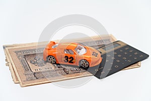 Toy car and calculator lie on a bundle of old Russian banknotes, auto insurance tradition