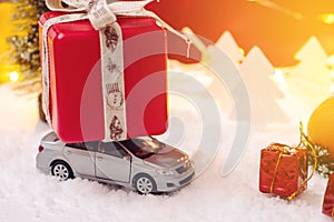 Toy car carries gifts in the Christmas and new year's eve on a red background. Concept of holiday shopping and discounts