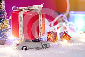 Toy car carries gifts in the Christmas and new year's eve on a red background. Concept of holiday shopping and discounts