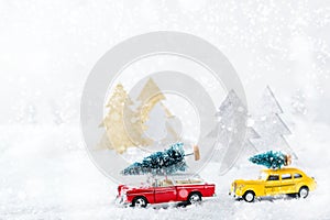 Toy car carrying christmas tree in a snow forest