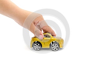 Toy car in a child`s hand isolated on a white background. Hand is playing with a toy car on white.