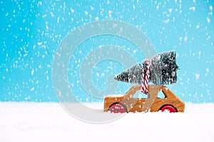 Toy car with Christmas tree in snowy winter