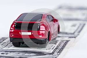 Toy Car on Dollar Banknotes as Road