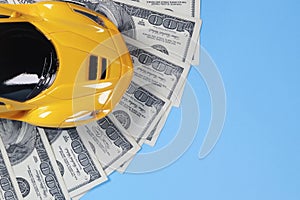 Toy car on dollars, cost concept, auto insurance