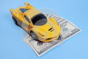 Toy car on dollars, cost concept, auto insurance