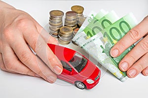 Toy car and euro money - insurance, rent and buying car