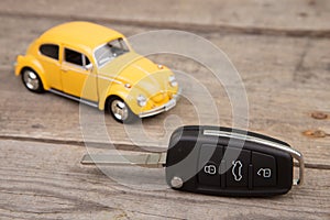 Toy car and key with remote alarm control on the wooden desk