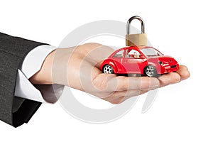 Toy car with lock on top in the hand of business man concept for insurance, buying, renting, fuel or service and repair costs photo