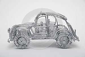 Toy car made of pliable wire against white background