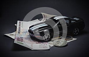 Toy car on money, on a black background.