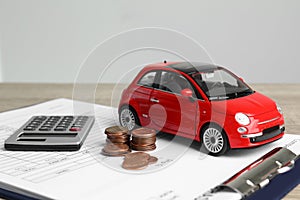 Toy car, money, calculator and insurance contract