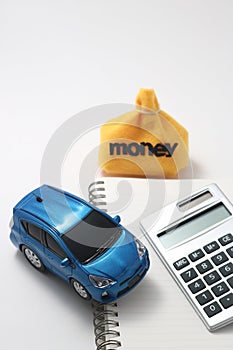 Toy car, money, calculator, and notebook