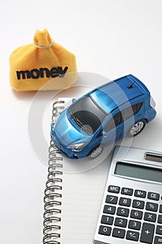 Toy car, money, calculator, and notebook