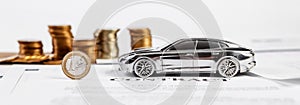 Toy car and money coins. Concept in insurance, loan and buying car