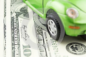 Toy car and money over white, rent, buy or insurance car concept