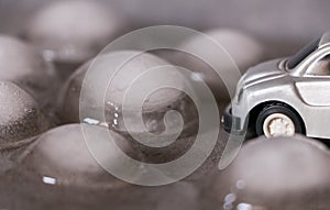 Toy car surrounded by ice cubes. Driving for bad weather concept