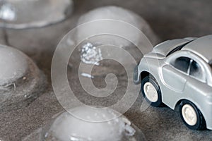 Toy car surrounded by ice cubes. Driving for bad weather concept