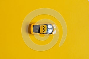 Toy car taxi on a yellow background with a top view