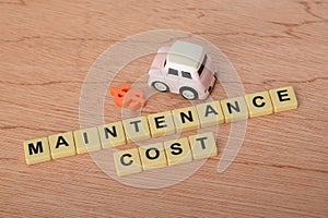 Toy car with text MAINTENANCE COST.Planning to manage transportation finance costs