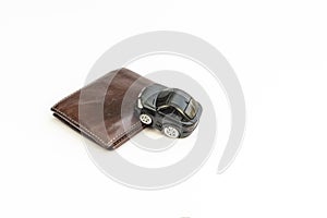 A toy car on a wallet on white background. Car price, cost, loans, debts and expenses concept