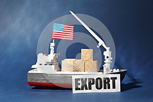 Toy cargo vessel with American flag and wooden cubes on blue background. Export concept