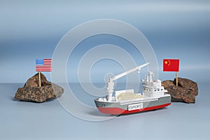 Toy cargo vessel, stones with American and Chinese flags on color background. Export concept