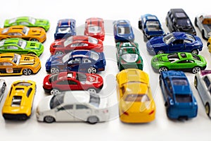 Toy cars of different colors arranged on a white background