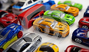 Toy cars of different colors arranged on a white background