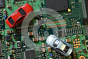 Toy cars on electronic board and microchip. Conceptual image for semiconductor shortage disrupting production of the automotive in