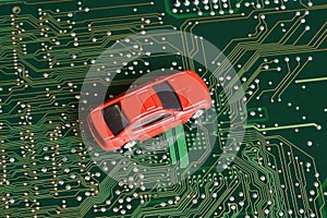 Toy cars on electronic board and microchip. The shortage of microchips and semiconductors creates a shortage of new cars.