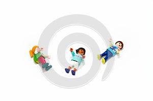 Toy children figures playing.Isolated on white background. They are three figures of various races and colors