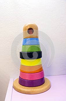 Toy children`s pyramid for development of intelligence and motility on light textural background