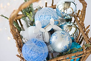 Toy for the Christmas tree in the form of a dog lies on a background of blue Christmas balls. 3d toys