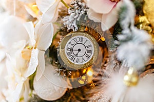Toy clock and snowflake with festive lights on Christmas tree. Christmas tree with decoration.Merry Christmas celebration. Gifts