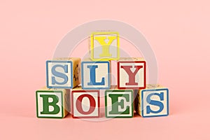 Toy colored cubes with letters on pink background