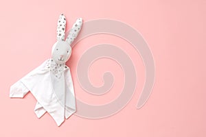 Toy Comforter bunny on a pink background. handy toy for grasping the hands of babies