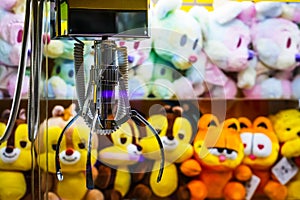 Toy crane vending machine, claw game or cabinet to catch the toys. Shopping, holiday activity, game of chance. Selective