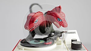 Toy dinosaur spinning discs on record player